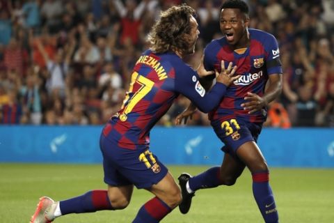 Barcelona's Ansu Fati, right, celebrates after with teammate Barcelona's Antoine Griezmann after scoring the opening goal during the Spanish La Liga soccer match between FC Barcelona and Valencia CF at the Camp Nou stadium in Barcelona, Spain, Saturday, Sep. 14, 2019. (AP Photo/Joan Monfort)