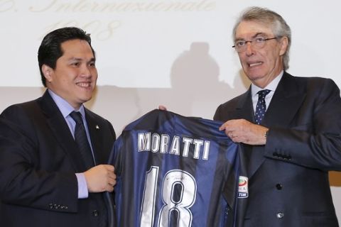Inter Milan newly elected President Erick Thohir, left, presents a jersey with his name to outgoing President Massimo Moratti in Milan, Italy, Friday, Nov. 15, 2013. Inter Milan owner Erick Thohir has been elected as club president, ending Massimo Moratti's 18-year spell in charge. Thohir, who bought a majority stake of Inter last month, was confirmed as the new president at an extraordinary board meeting on Friday. (AP Photo/Antonio Calanni)