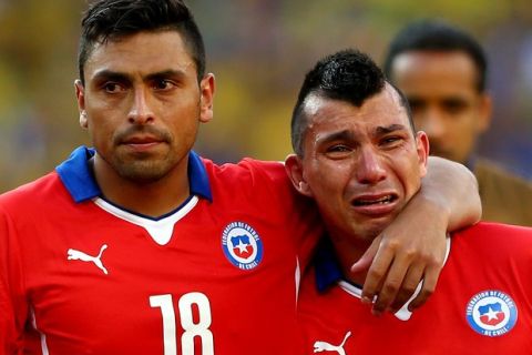 BELO HORIZONTE, BRAZIL - JUNE 28: Gonzalo Jara (L) and Gary Medel of Chile react after being defeated by Brazil in a penalty shootout during the 2014 FIFA World Cup Brazil round of 16 match between Brazil and Chile at Estadio Mineirao on June 28, 2014 in Belo Horizonte, Brazil.  (Photo by Quinn Rooney/Getty Images)
