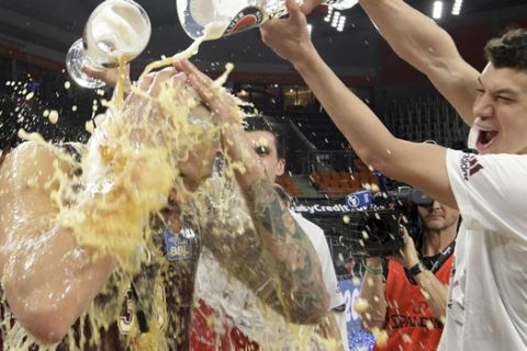 Bayern Munich's Vladimir Lucic, right, delivers a shower of beer to  Maik Zirbes  as they celebrate their victory in the German basketball Cup Final Four final against Alba Berlin in Neu-Ulm, Germany, Sunday, Feb. 18, 2018. (Stefan Puchner/dpa via AP)