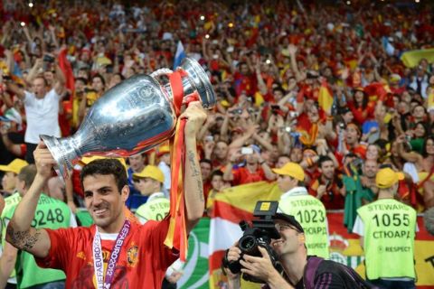 Spanish midfielder Cesc Fabregas holds the trophy after winning the Euro 2012 football championships final match Spain vs Italy on July 1, 2012 at the Olympic Stadium in Kiev.      AFP PHOTO / DAMIEN MEYER        (Photo credit should read DAMIEN MEYER/AFP/GettyImages)