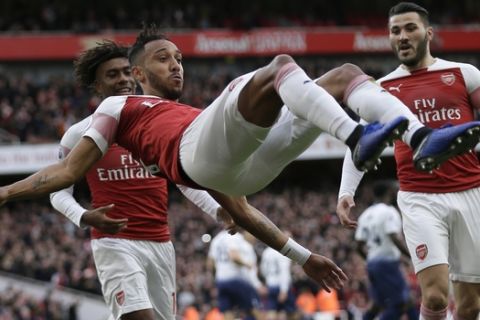 Arsenal's Pierre-Emerick Aubameyang celebrates with his teammates after scoring his side's opening goal from the penalty spot during the English Premier League soccer match between Arsenal and Tottenham Hotspur at the Emirates Stadium in London, Sunday Dec. 2, 2018. (AP Photo/Tim Ireland)