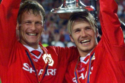 FILE - In this May 26, 1999, file photo, Manchester United's Teddy Sheringham, left, and David Beckham celebrate lift the trophy after defeating Bayern Munich 2-1 to win the Champions League soccer final in Barcelona, Spain. Manchester United took a few years to re-establish itself in European competition after the ban on English club participation was lifted. In 1999, United was going for a historic English treble when it met Bayern Munich. With the game already in injury time, any hope of adding the Champions League to the Premier League and FA Cup looked forlorn. However, in a stunning turnaround, goals from Sheringham and Ole Gunnar Solskjaer saw United win the trophy for the first time since 1968.(AP Photo/Camay Sungu, File)