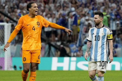 Argentina's Lionel Messi looks at Virgil van Dijk of the Netherlands, left, gesturing during the World Cup quarterfinal soccer match between the Netherlands and Argentina, at the Lusail Stadium in Lusail, Qatar, Friday, Dec. 9, 2022. (AP Photo/Ricardo Mazalan)
