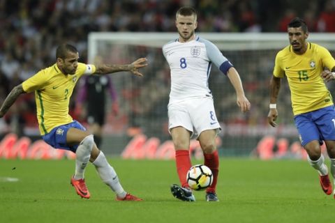 England's Eric Dier, center, controls the ball flanked by Brazil's Dani Alves, left, and Brazil's Paulinho during the international friendly soccer match between England and Brazil at Wembley stadium in London, Britain, Tuesday, Nov. 14, 2017. (AP Photo/Matt Dunham)