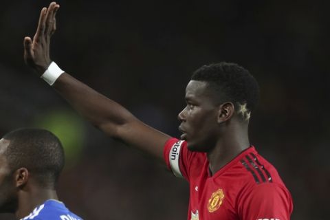 Manchester United's Paul Pogba, gestures to a teammates and who has two gold stars colouring the back of his head, a reference to the 2 World Cups that France have won, the during the English Premier League soccer match between Manchester United and Leicester City at Old Trafford, in Manchester, England, Friday, Aug. 10, 2018. (AP Photo/Jon Super)