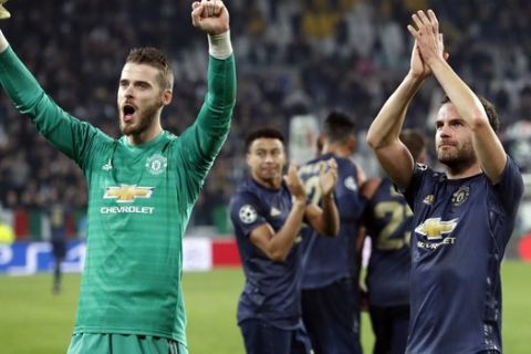Manchester United's goalkeeper David de Gea, left, and Juan Mata celebrate at the end of the Champions League group H soccer match between Juventus and Manchester United at the Allianz stadium in Turin, Italy, Wednesday, Nov. 7, 2018. Manchester won 2-1. (AP Photo/Antonio Calanni)
