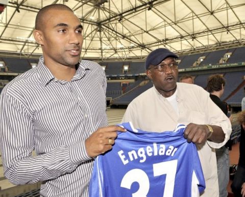 Dutch national soccer player Orlando Engelaar, left, and his father Wensley Engelaar hold Orlando's new shirt during his presentation at a news conference as new player of German first division, Bundesliga, soccer club FC Schalke 04 in Gelsenkirchen, Germany, Tuesday, July 15, 2008. (AP Photo/Martin Meissner)