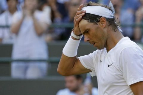 Spain's Rafael Nadal takes off his headband after beating Japan's Sugita Yuichi in a singles match during day two of the Wimbledon Tennis Championships in London, Tuesday, July 2, 2019. (AP Photo/Kirsty Wigglesworth)