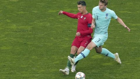 Portugal's Cristiano Ronaldo, left, duels for the ball with Netherlands' Matthijs de Ligt during the UEFA Nations League final soccer match between Portugal and Netherlands at the Dragao stadium in Porto, Portugal, Sunday, June 9, 2019. (AP Photo/Luis Vieira)