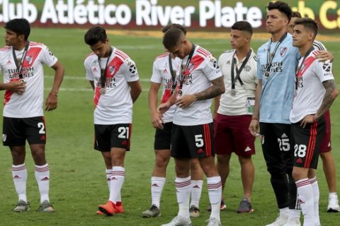 Players of Argentina's River Plate stand on the field after losing 1-2 against Brazil's Flamengo the Copa Libertadores final soccer match at the Monumental stadium in Lima, Peru, Saturday, Nov. 23, 2019. (AP Photo/Fernando Vergara)