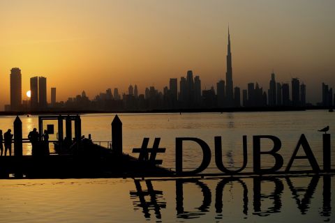 FILE - People enjoy the sunset with the view of city skyline and the world tallest tower, Burj Khalifa, in Dubai, United Arab Emirates, on Jan. 29, 2021. The FIFA World Cup may be bringing as many as 1.2 million fans to Qatar, but the nearby flashy emirate of Dubai is also looking to cash in on the major sports tournament taking place just a short flight away. (AP Photo/Kamran Jebreili, File)