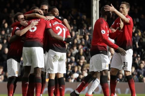 Manchester United's Paul Pogba celebrates with teammates after scoring his side's third goal from penalty during the English Premier League soccer match between Fulham and Manchester United at Craven Cottage stadium in London, Saturday, Feb. 9, 2019. (AP Photo/Matt Dunham)