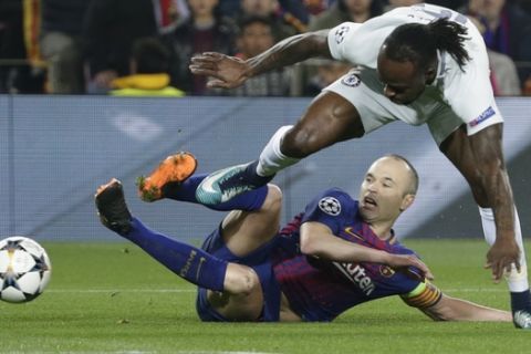 Barcelona's Andres Iniesta, bottom, and Chelsea's Victor Moses vie for the ball during the Champions League round of sixteen second leg soccer match between FC Barcelona and Chelsea at the Camp Nou stadium in Barcelona, Spain, Wednesday, March 14, 2018. (AP Photo/Emilio Morenatti)