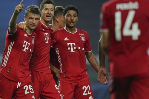 Bayern's Serge Gnabry, right, celebrates his side's second goal with teammates Robert Lewandowski, center, and Thomas Mueller during the Champions League semifinal soccer match between Lyon and Bayern Munich at the Jose Alvalade stadium in Lisbon, Portugal, Wednesday, Aug. 19, 2020. (Miguel A. Lopes/Pool via AP)