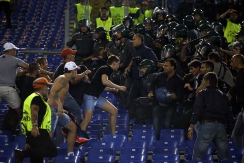 FILE - In this Wednesday, Sept. 17, 2014 file photo, CSKA fans clash with police during a Champions League, Group E soccer match between Roma and CSKA, at the Olympic stadium, in Rome. UEFA banned CSKA Moscow fans from attending any Champions League group matches this season after a series of racist and violent incidents, making the toughest use yet of its stronger powers to tackle discrimination in football. CSKA was ordered to play its next three UEFA competition matches in an empty stadium by UEFA's disciplinary panel on Friday, Oct. 3, 2014. (AP Photo/Alessandra Tarantino, File)