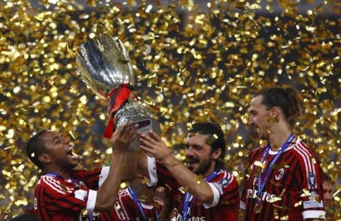 AC Milan's Robinho (L), Gennaro Ivan Gattuso (C) and Zlatan Ibrahimovic celebrate with the trophy after winning the Italian Super Cup soccer match against Inter Milan at the National Olympic Stadium, also known as the Bird's Nest, in Beijing, August 6, 2011. REUTERS/David Gray (CHINA - Tags: SPORT SOCCER IMAGES OF THE DAY)