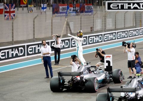 Mercedes driver Lewis Hamilton of Britain, center, celebrates after getting the pole position in the qualifying session for the Emirates Formula One Grand Prix at the Yas Marina racetrack in Abu Dhabi, United Arab Emirates, Saturday, Nov. 24, 2018. The Emirates Formula One Grand Prix will take place on Sunday. (AP Photo/Hassan Ammar)