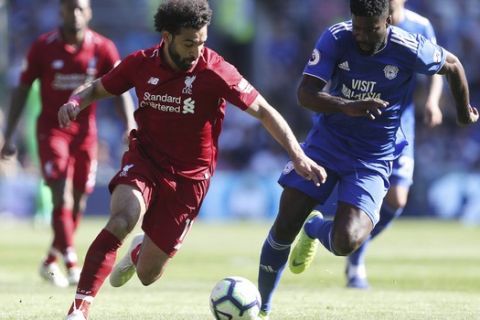 Liverpool's Mohamed Salah and Cardiff City's Bruno Ecuele Manga, right, battle for the ball during the English Premier League soccer match at The Cardiff City Stadium, Cardiff, Wales, Sunday April 21, 2019. (David Davies/PA via AP)