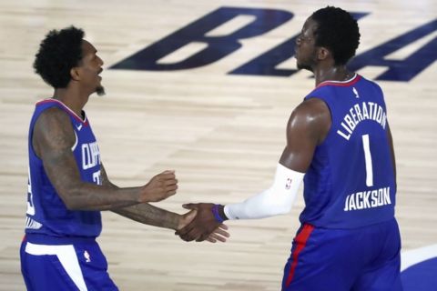 Los Angeles Clippers' Lou Williams (23) and guard Reggie Jackson (1) celebrate during the second half against the Portland Trail Blazers in an NBA basketball game Saturday, Aug. 8, 2020, in Lake Buena Vista, Fla. (Kim Klement/Pool Photo via AP)