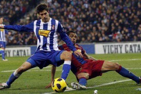 Barcelona's Dani Alves (R) fights for the ball with Espanyol's Didac Vila during their Spanish first division soccer league match at Conella-El Prat Stadium, near Barcelona, December 18, 2010. REUTERS/Albert Gea (SPAIN - Tags: SPORT SOCCER)