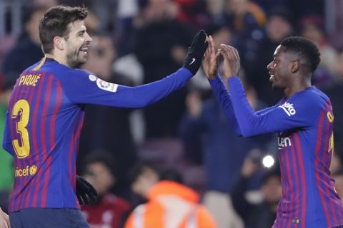 FC Barcelona's Dembele, right, celebrates with his teammate Gerard Pique during the Spanish La Liga soccer match between FC Barcelona and Leganes at the Camp Nou stadium in Barcelona, Spain, Sunday, Jan. 20, 2019. (AP Photo/Manu Fernandez)