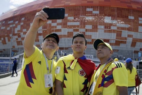 Fans take pictures in front of the stadium prior to the group H match between Colombia and Japan at the 2018 soccer World Cup in the Mordavia Arena in Saransk, Russia, Tuesday, June 19, 2018. (AP Photo/Mark Baker)