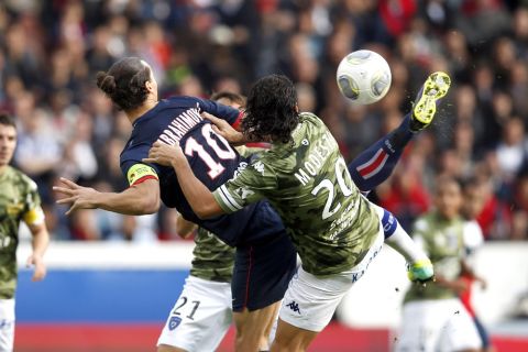 Paris St Germain's Zlatan Ibrahimovic challenges Bastia's Francois-Joseph Modesto (R) and scores his first goal during their French Ligue 1 soccer match at the Parc des Princes Stadium in Paris October 19, 2013. REUTERS/Benoit Tessier (FRANCE - Tags: SPORT SOCCER TPX IMAGES OF THE DAY) - RTX14H19