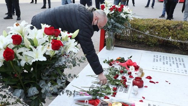 Ο Μιχάλης Κουντούρης αφήνει ένα τριαντάφυλλο στο μνημείο για τα θύματα της Θύρας 7