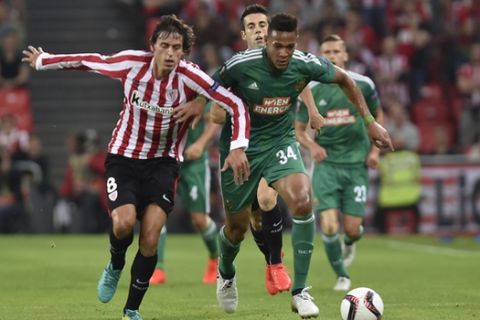 Athletic Bilbao's Ander Iturraspe, left, duels with Rapid Wien IJoelintonc, during the Europa League Group F soccer match between Athletic Bilbao and Rapid Wien, at San Mames stadium, in Bilbao, northern Spain, Thursday, Sept. 29, 2016. (AP Photo/Alvaro Barrientos))