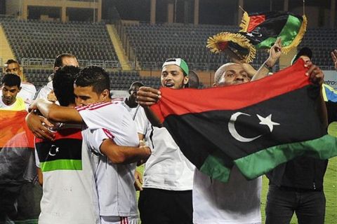 FILE - In this Saturday Sept. 3, 2011 file photo the Libyan national soccer team, holding the pre-Gadhafi flag, celebrates their win in a match, their first since rebels took control of the Libyan capital, against Mozambique in Cairo, Egypt.  Top-ranked African team Ivory Coast and World Cup quarterfinalist Ghana were already strong contenders for the African Cup, which kicks off on Saturday Jan 21, 2012, because of their star-studded squads. But the absence of former champions Egypt, Cameroon, Nigeria and South Africa has made the Ivorians and Ghanaians the standout countries at this year's tournament, which will be co-hosted by West African neighbors Gabon and Equatorial Guinea. Libya battled through civil war at home to make its third African Cup. (AP Photo)