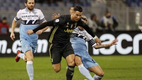 Juventus' Cristiano Ronaldo, left, is tackled by Lazio's Luis Alberto during the Serie A soccer match between Lazio and Juventus at the Olympic stadium, in Rome, Sunday, Jan. 27, 2019. (AP Photo/Gregorio Borgia)