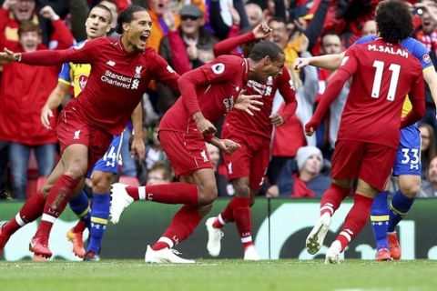 Liverpool's Joel Matip, centre, celebrates scoring his side's second goal of the game, during the English Premier League soccer match between Liverpool and Southampton, at Anfield, in Liverpool, England, Saturday, Sept. 22, 2018. (Dave Thompson/PA via AP)