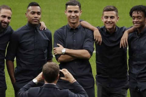 Juventus' Cristiano Ronaldo, center, has his photo taken with team players on the pitch at the Metropolitano stadium in Madrid, Spain, Tuesday Sept. 17, 2019. Juventus will play Atletico Madrid in a Group D Champions League soccer match on Wednesday. (AP Photo/Manu Fernandez)