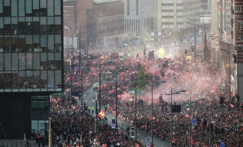 Fans watch as smoke from flares engulf the scene while Liverpool soccer team ride an open top bus during the Champions League Cup Winners Parade through the streets of Liverpool, England, Sunday June 2, 2019.  Liverpool is champion of Europe for a sixth time after beating Tottenham 2-0 in the Champions League final played in Madrid Saturday. (Danny Lawson/PA via AP)