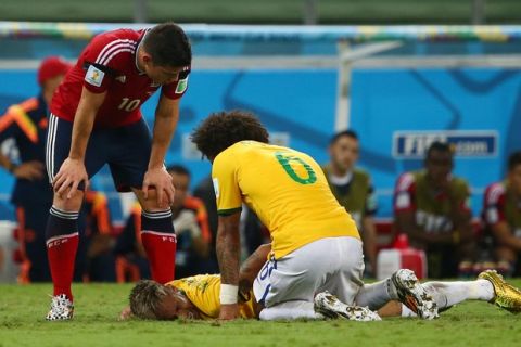 FORTALEZA, BRAZIL - JULY 04:  Neymar of Brazil lies on the field after a challenge as teammate Marcelo and James Rodriguez of Colombia look on during the 2014 FIFA World Cup Brazil Quarter Final match between Brazil and Colombia at Castelao on July 4, 2014 in Fortaleza, Brazil.  (Photo by Robert Cianflone/Getty Images)