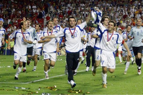 epa000226693 Greek captain Theodoros Zagorakis (front right) and Georgios Karagounis carry the cup in front of their team-mates after the team won the Euro 2004 final between Portugal and Greece at Luz stadium in Lisbon on Sunday, 04 July 2004.  EPA/NUNO VEIGA NO MOBILE PHONE APPLICATIONS