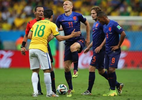 BRASILIA, BRAZIL - JULY 12: Arjen Robben of the Netherlands reacts after a challenge by Hernanes of Brazil as referee Djamel Haimoudi looks on during the 2014 FIFA World Cup Brazil Third Place Playoff match between Brazil and the Netherlands at Estadio Nacional on July 12, 2014 in Brasilia, Brazil.  (Photo by Dean Mouhtaropoulos/Getty Images)