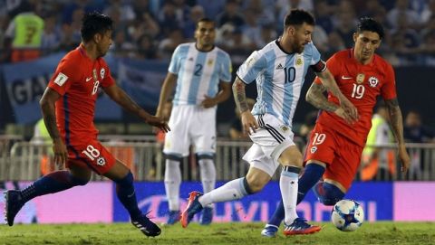 Argentinas Lionel Messi dribbles past Chiles Pedro Pablo Hernandez, right, and Chiles Gonzalo Jara, left, during a 2018 Russia World Cup qualifying soccer match in Buenos Aires, Argentina, Thursday, March 23, 2017.(AP Photo/Agustin Marcarian)