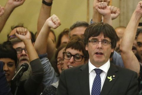 Catalan President Carles Puigdemont sings the Catalan anthem inside the parliament after a vote on independence in Barcelona, Spain, Friday, Oct. 27, 2017. Catalonia's regional parliament has passed a motion saying they are establishing an independent Catalan Republic.(AP Photo/Manu Fernandez)