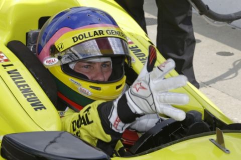 Jacques Villeneuve, of Canada, puts on his gloves as he prepares to drive during practice for the Indianapolis 500 IndyCar auto race at the Indianapolis Motor Speedway in Indianapolis, Tuesday, May 13, 2014. (AP Photo)