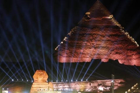 Lights illuminates the sky over the historical site of the Giza Pyramids and Sphinx to celebrate the African Cup of Nations draw in Cairo, Egypt, Friday, April 12, 2019. The tournament which will feature 24 teams will be held in Egypt in June 2019. (AP Photo/Amr Nabil)