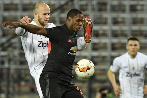 LASK's Gernot Trauner, left, and Manchester United's Odion Ighalo challenge for the ball during the Europa League round of 16 first leg soccer match between Linzer ASK and Manchester United in Linz, Austria, Thursday, March 12, 2020. The match is being played in an empty stadium because of the coronavirus outbreak. (AP Photo/Kerstin Joensson)