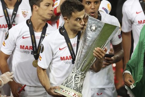 Sevilla's Sergio Reguilon kisses the trophy after winning the Europa League final soccer match between Sevilla and Inter Milan in Cologne, Germany, Friday, Aug. 21, 2020. (Lars Baron, Pool Photo via AP)