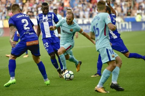 FC Barcelona's Andres Iniesta, center, fights for the ball beside Rodrigo Ely, second left, during the Spanish La Liga soccer match between FC Barcelona and Deportivo Alaves, at Mendizorroza stadium, in Vitoria, northern Spain, Saturday, Aug. 26, 2017. (AP Photo/Alvaro Barrientos)
