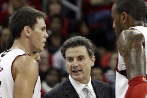 Louisville coach Rick Pitino talks to players Kyle Kuric, left, and Terrence Jennings, right, during a timeout in their NCAA college basketball game against UNLV in Louisville, Ky., Saturday, Dec. 11, 2010.  (AP Photo/Garry Jones)