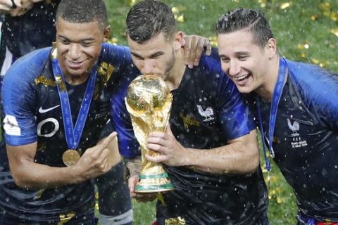 France's Kylian Mbappe, Lucas Hernandez, Florian Thauvin hold the trophy after the final match between France and Croatia at the 2018 soccer World Cup in the Luzhniki Stadium in Moscow, Russia, Sunday, July 15, 2018. (AP Photo/Frank Augstein)