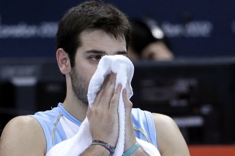 Argentina's Luciano de Cecco sits on the bench following his team's loss to Brazil in a men's quarterfinal volleyball match at the 2012 Summer Olympics, Wednesday, Aug. 8, 2012, in London. (AP Photo/Jeff Roberson)