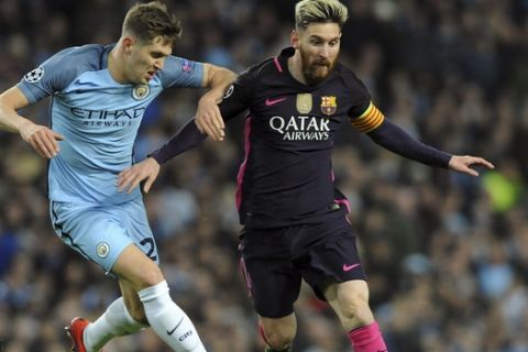 Manchester City's John Stones, left, and Barcelona's Lionel Messi, right, challenge for the ball during the Champions League group C soccer match between Manchester City and Barcelona at the Etihad stadium in Manchester, England, Tuesday, Nov. 1, 2016. (AP Photo/Rui Vieira)