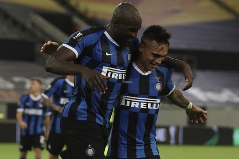 Inter Milan's Romelu Lukaku, left, celebrates after scoring his sides's fourth goal with his teammate Lautaro Martinez during the Europa League semifinal soccer match between Inter Milan and Shakhtar Donetsk at Dusseldorf Arena, in Duesseldorf, Germany, Monday, Aug. 17, 2020. Inter won 5-0. (Lars Baron/Pool Photo via AP)